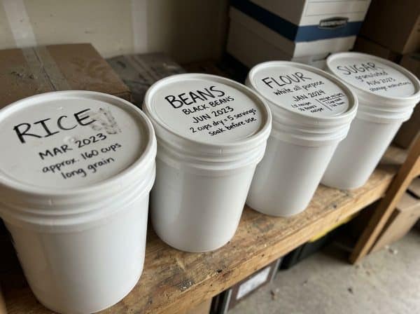 Labeled five gallon buckets showing contents and date for organized budget long-term food storage